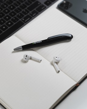 A phone headset resting beside a notepad and pen.