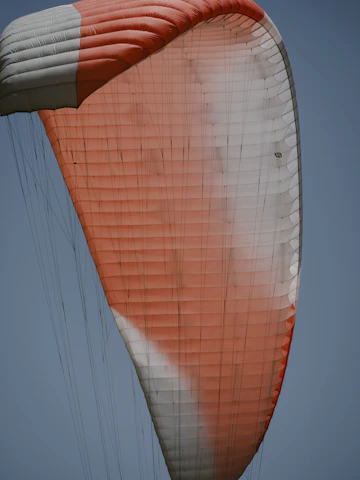 Close-up of a colorful parachute canopy fully deployed against a clear sky.