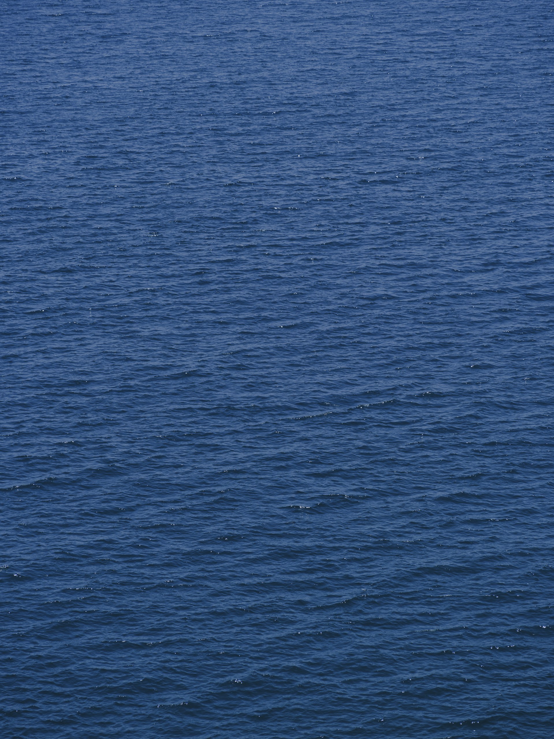 a lone boat floating in the middle of a large body of water