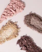 three different colored eyeshades on a white surface