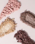 three different colored eyeshades on a white surface