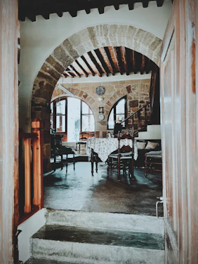 Cozy rustic dining room with terracotta walls and olive green accents, softly lit for a warm Mediterranean atmosphere.