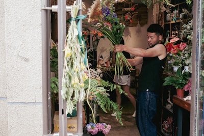 a man arranging flowers in a flower shop