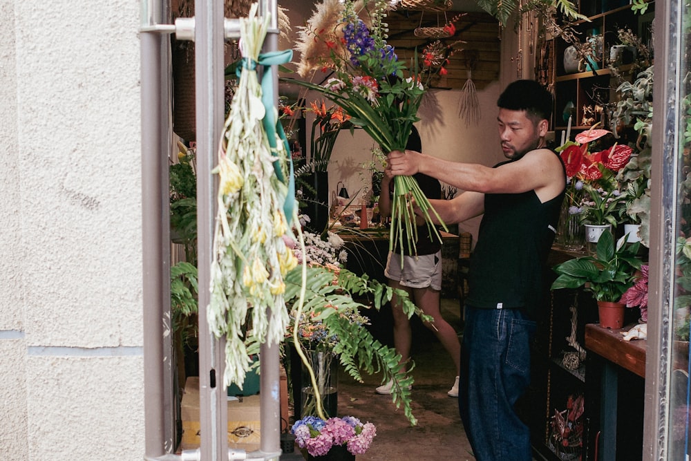 a man arranging flowers in a flower shop