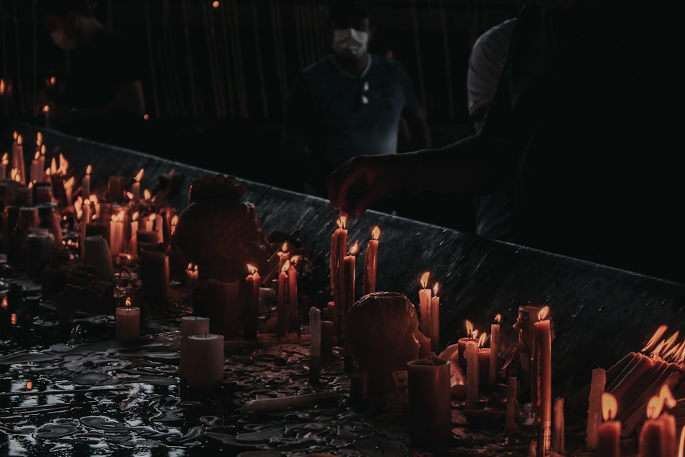 a man lighting candles in a dark room