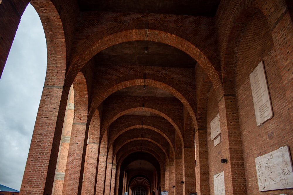 a long hallway with brick walls and arches
