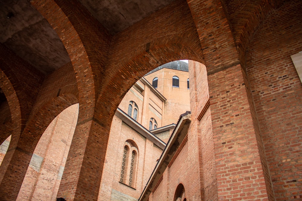 a building with arches and a clock tower in the background