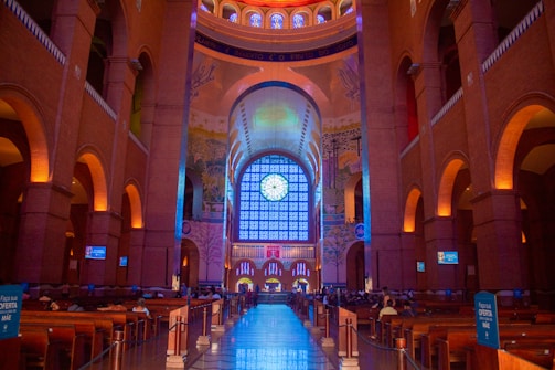 the inside of a large building with a clock on the wall