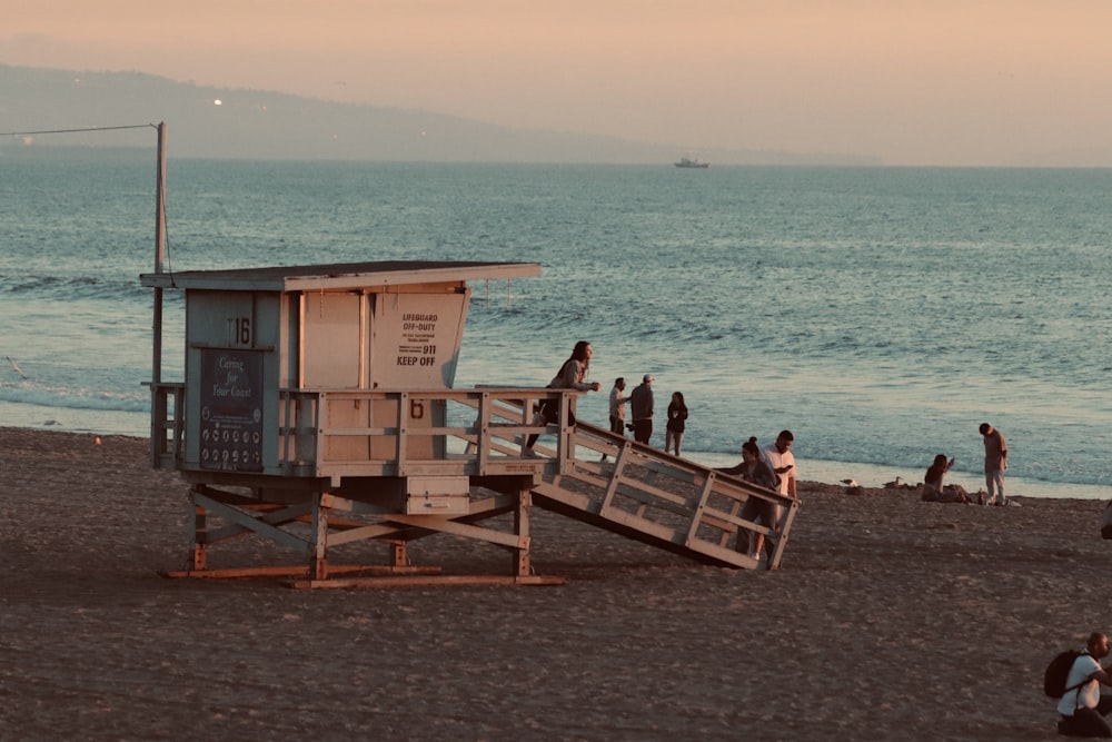 a group of people standing on top of a sandy beach