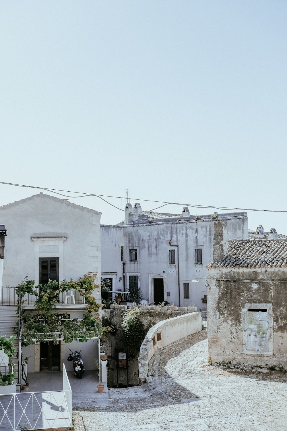 um edifício branco com uma varanda ao lado de uma rua