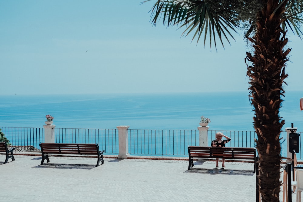 Una persona seduta su una panchina con vista sull'oceano