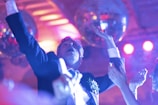 Close-up of a joyful guest dancing at a vibrant social party under colorful lights.