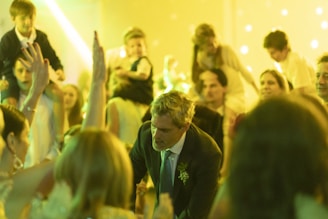 a man in a suit and tie standing in front of a crowd of people