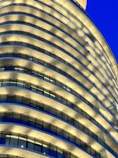 A modern luxury building under construction against a deep black sky with golden accents.
