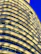 High-end apartment building facade featuring deep blue and gold lighting at night.