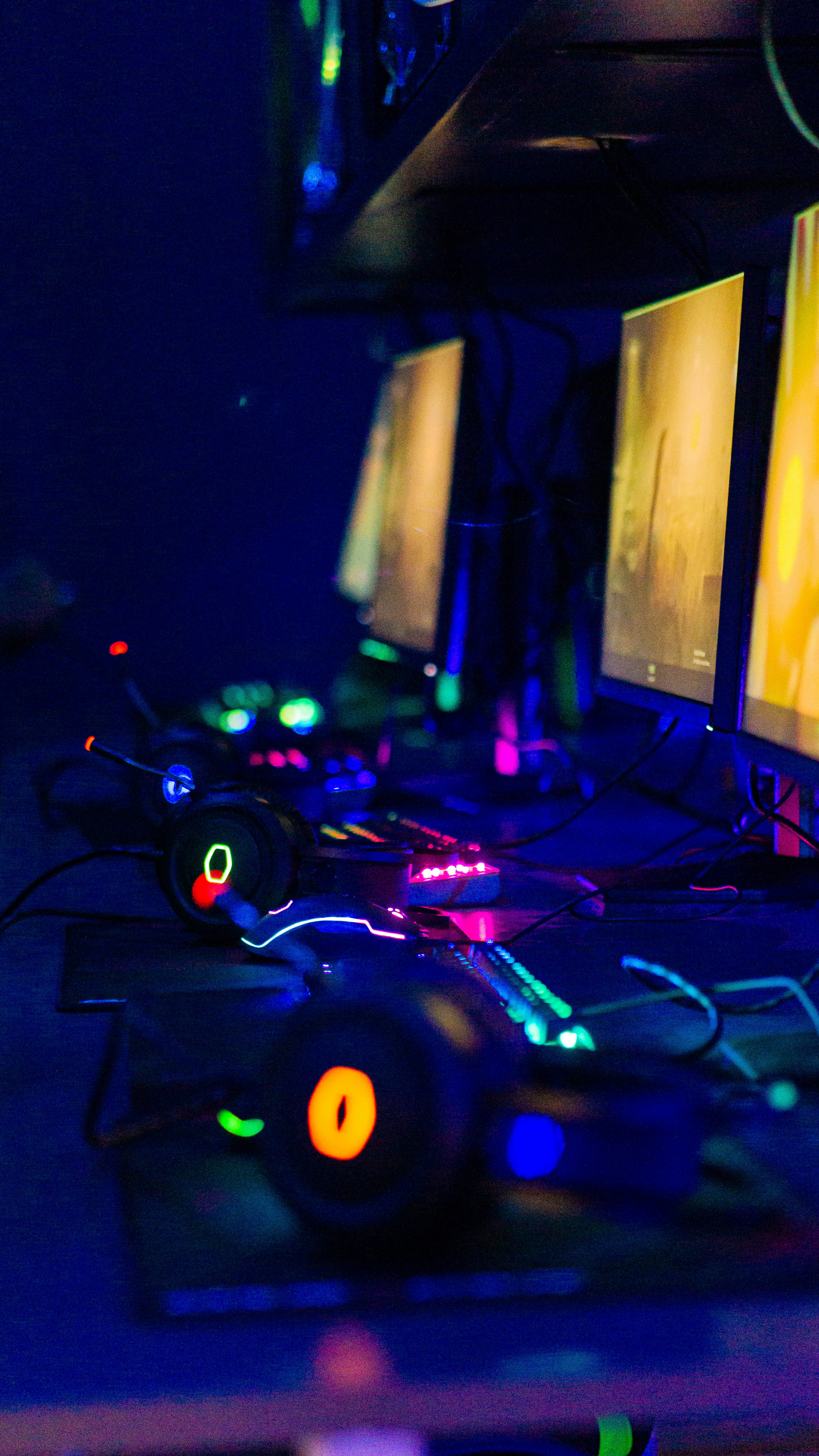 Competitive gaming setup in dark room with monitor illuminating face in shadows