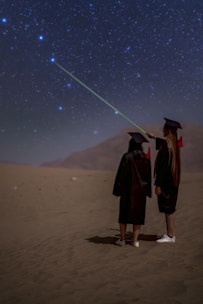 a couple of people that are standing in the sand