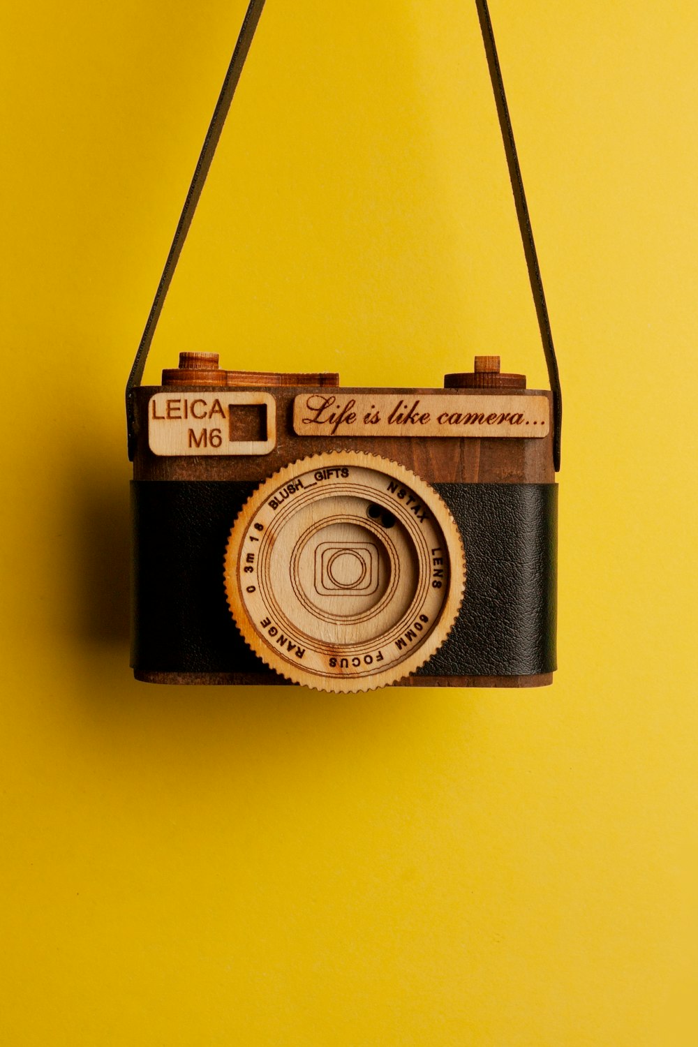 a camera hanging on a yellow wall