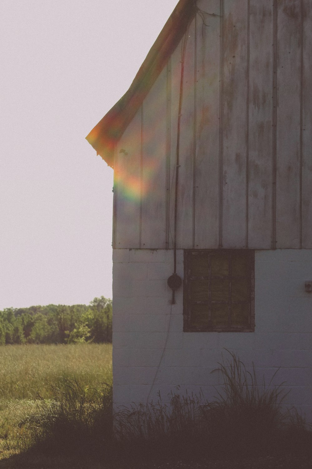a white barn with a rainbow in the sky