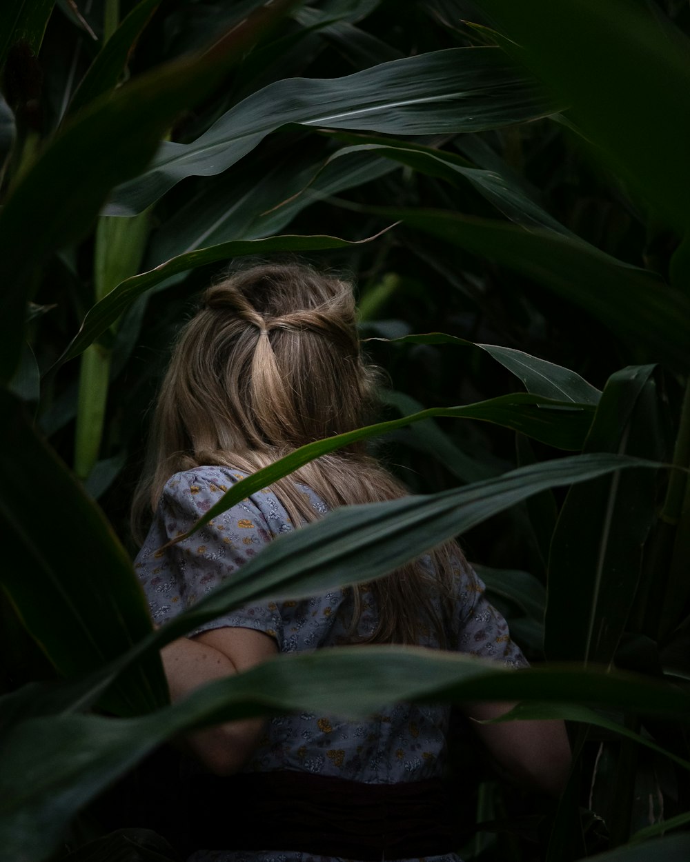 uma mulher em pé em um campo de grama alta