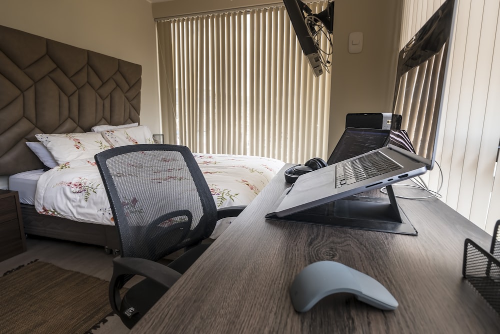 a laptop computer sitting on top of a wooden desk