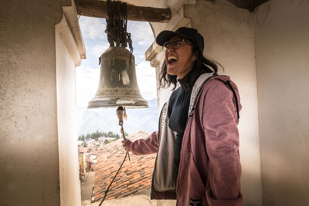 a woman in a hat is holding a bell