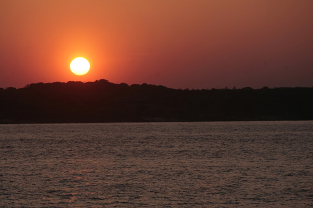 the sun is setting over a body of water