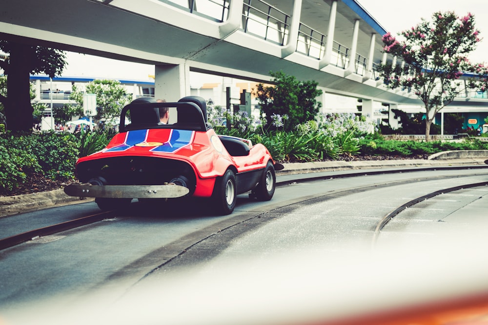 a red and blue toy car driving down a track
