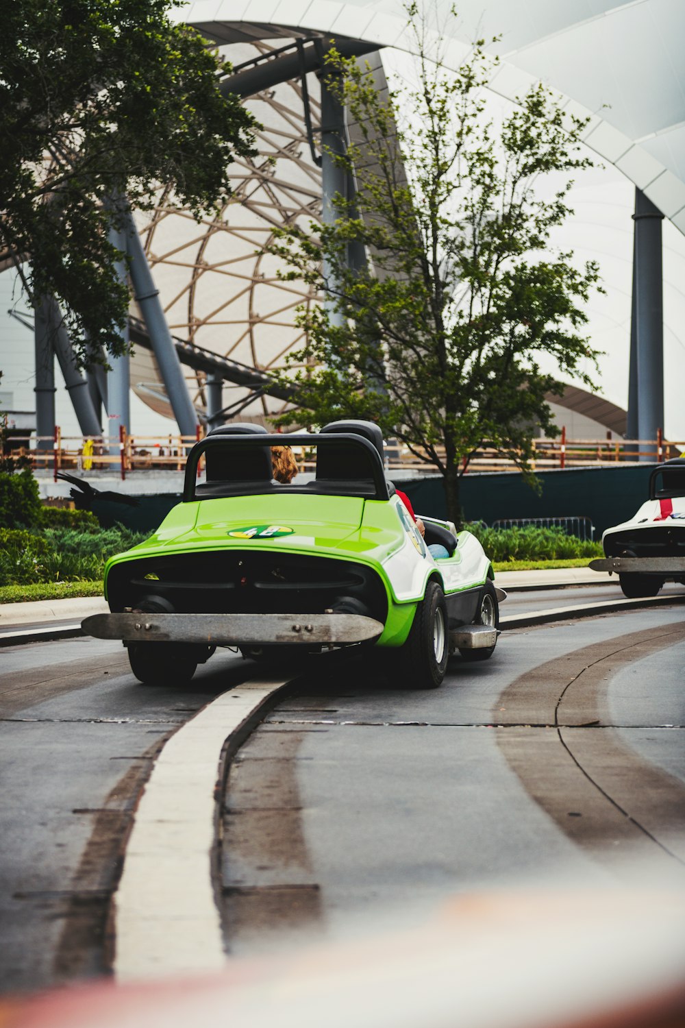 a green and white car driving down a street