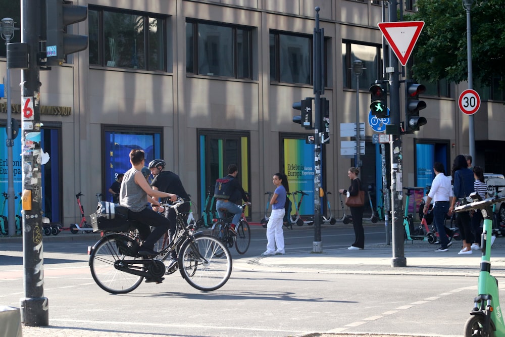 a man riding a bike down a street next to a traffic light