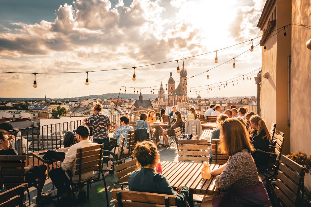 a group of people sitting on top of a wooden bench