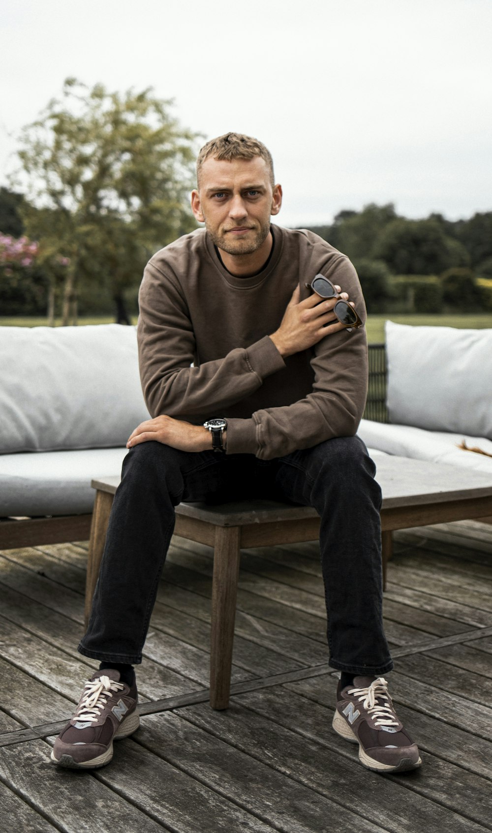 a man sitting on a bench with his arms crossed