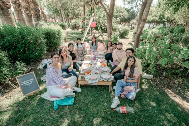 A group of friends enjoying a picnic in a lush park setting.