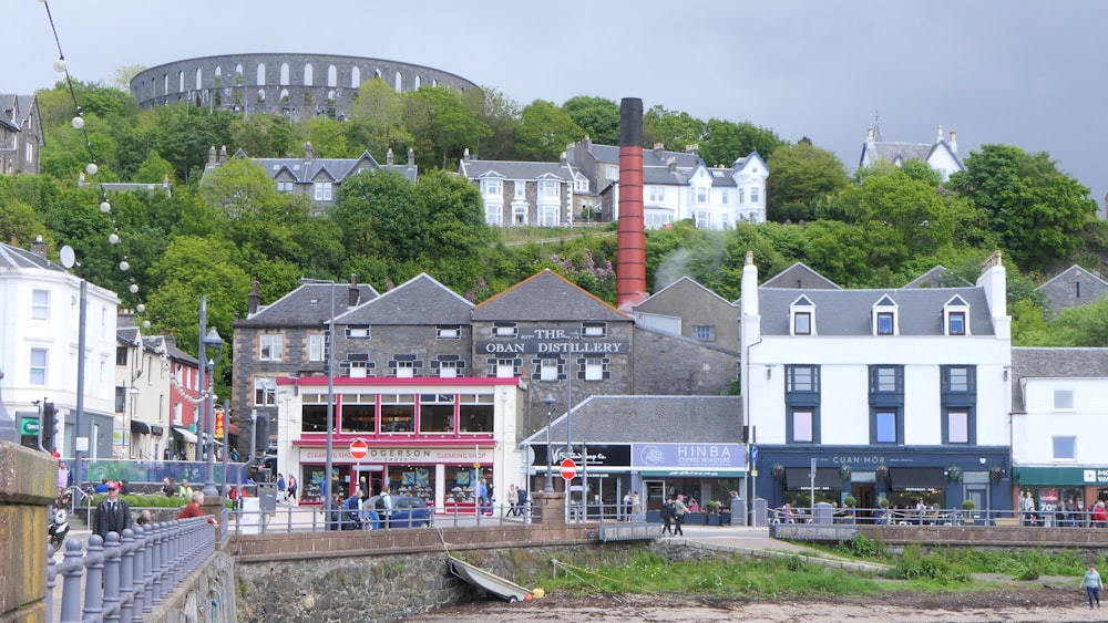 a group of buildings sitting on top of a lush green hillside