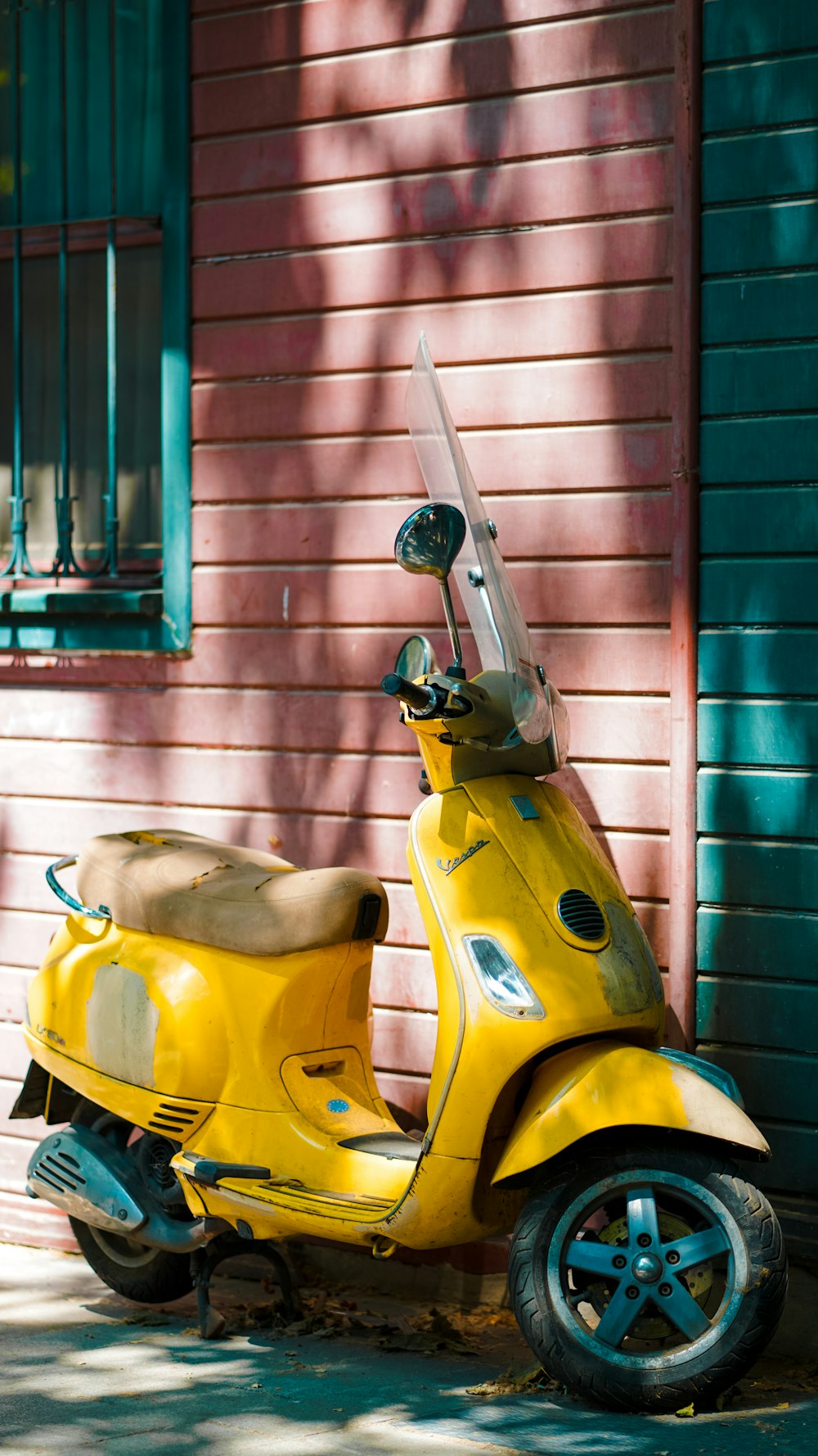 Un scooter jaune garé devant un immeuble