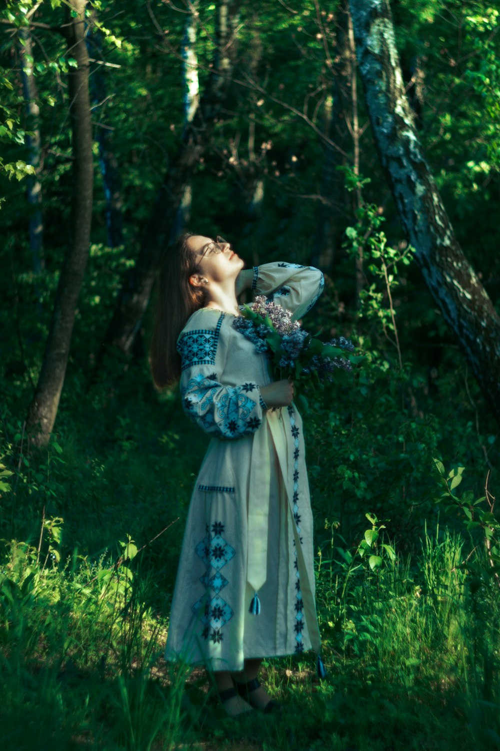 a woman in a dress standing in the woods