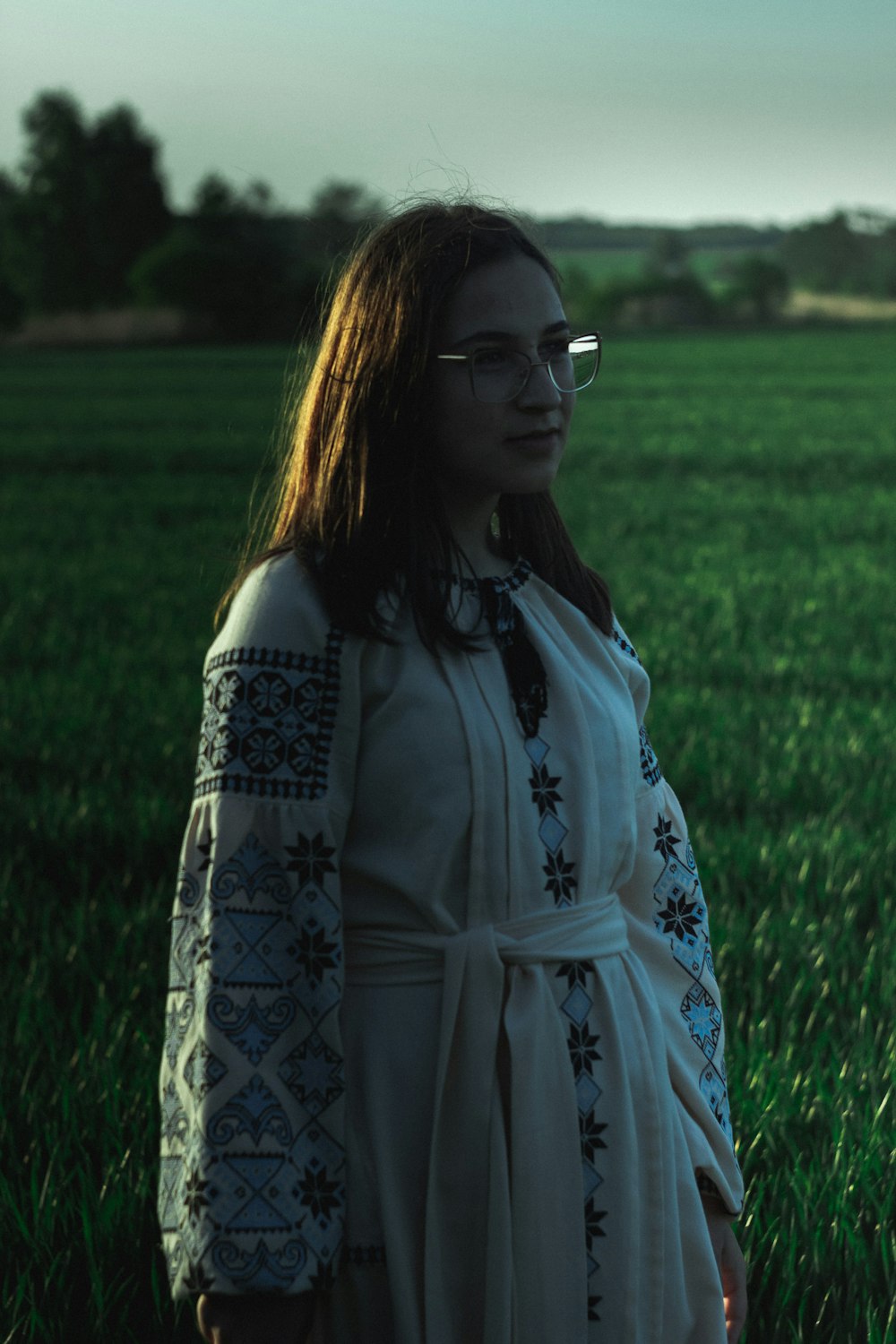 a woman in a white dress standing in a field