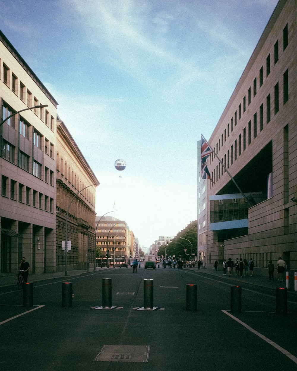 a city street with buildings and a balloon flying in the sky