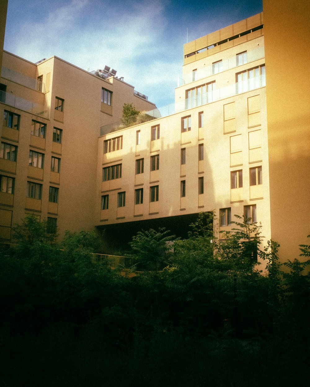 a tall building sitting next to a lush green forest