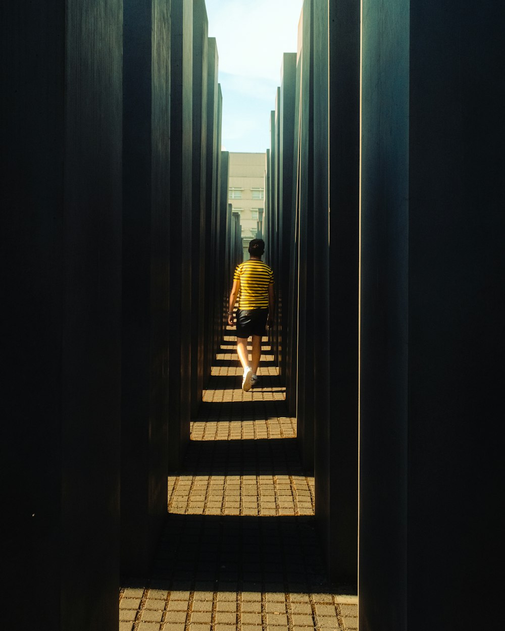 a man walking through a tunnel of doors