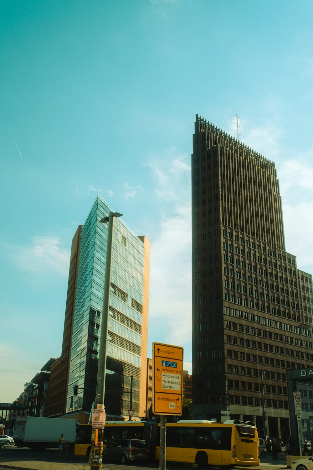 a yellow bus driving down a street next to tall buildings