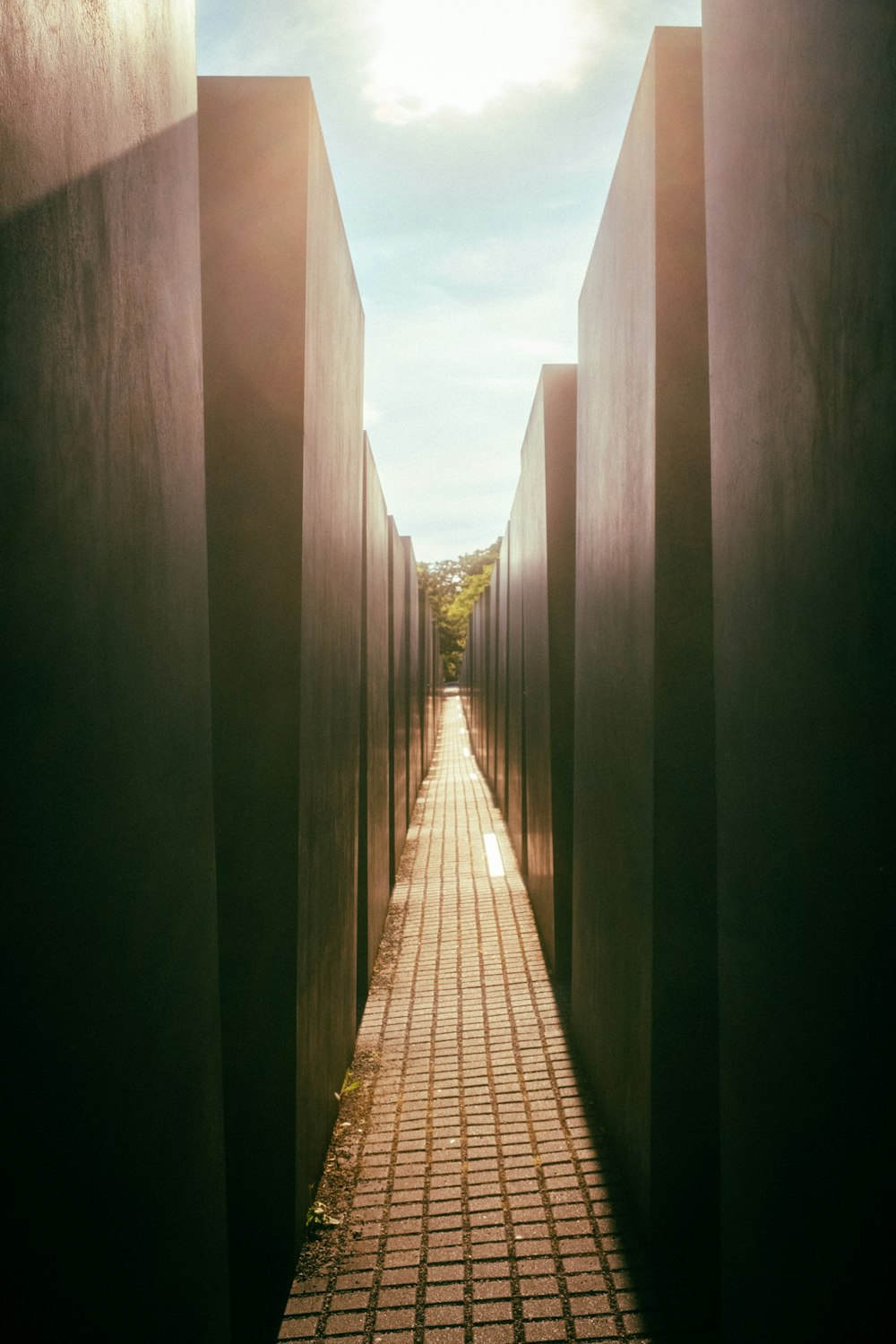 a walkway between two buildings with a sky in the background