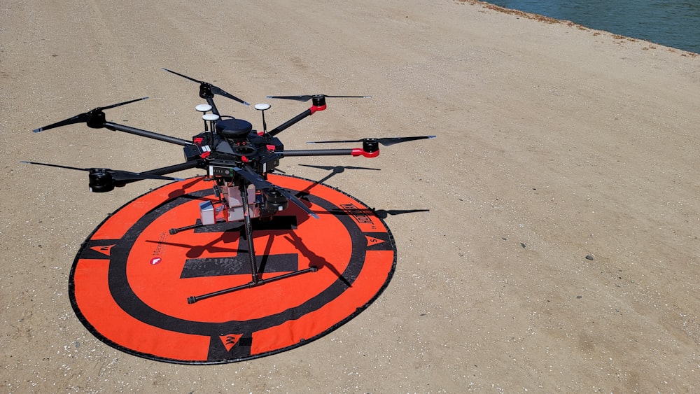 a black and red helicopter sitting on top of a beach
