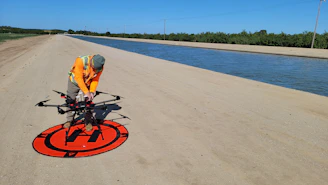 a man in an orange vest is working on a red and black sign