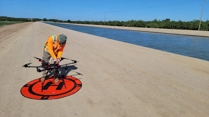 a man in an orange vest is working on a red and black sign