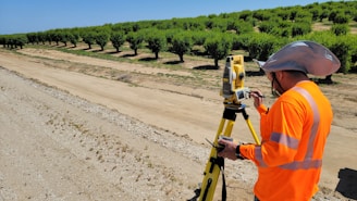 a man in an orange shirt is using a tripod