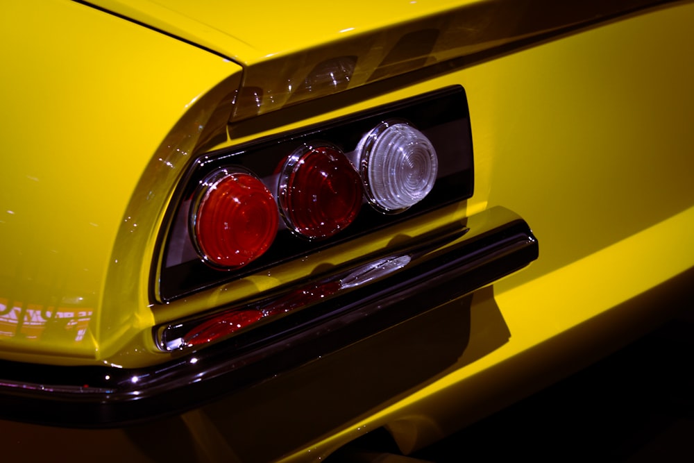 a close up of the tail lights of a yellow car