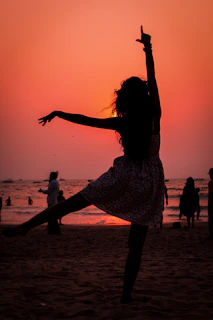 Dancers gracefully moving in a sunset-lit beachside zouk event.