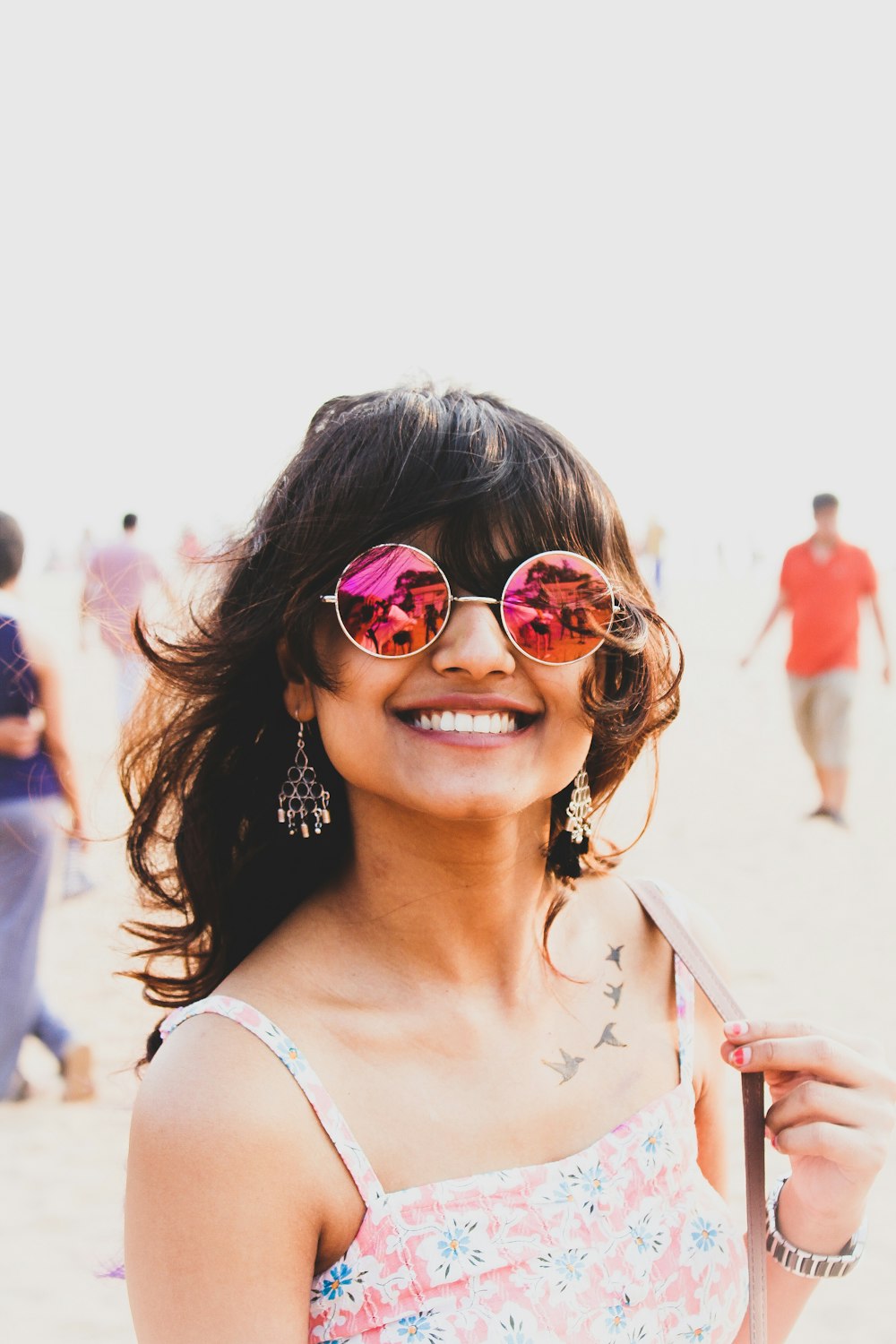 a woman wearing sunglasses and smiling at the camera
