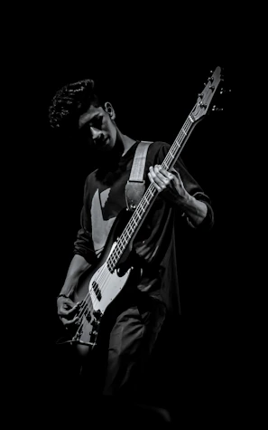 Guitarist caught mid-solo with intense focus and dramatic shadows.